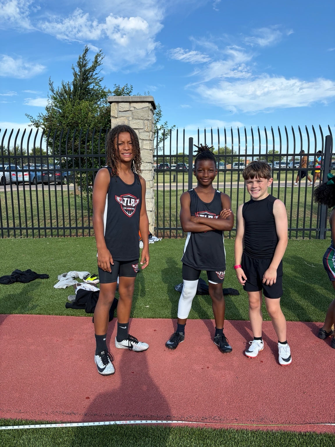 Three young TLR athletes together beside the track